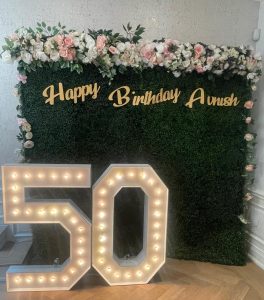 Marquee numbers framed by a green flower wall in Innisfil